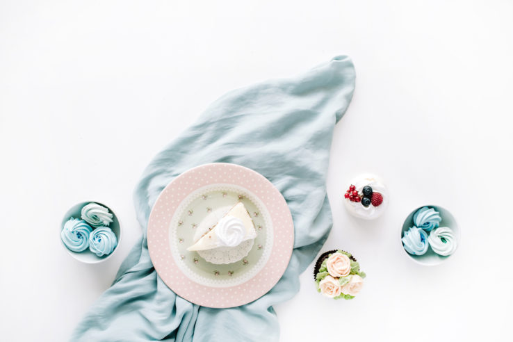 Breakfast composition with cakes on retro plate and blue textile on with background. Flat lay, top view